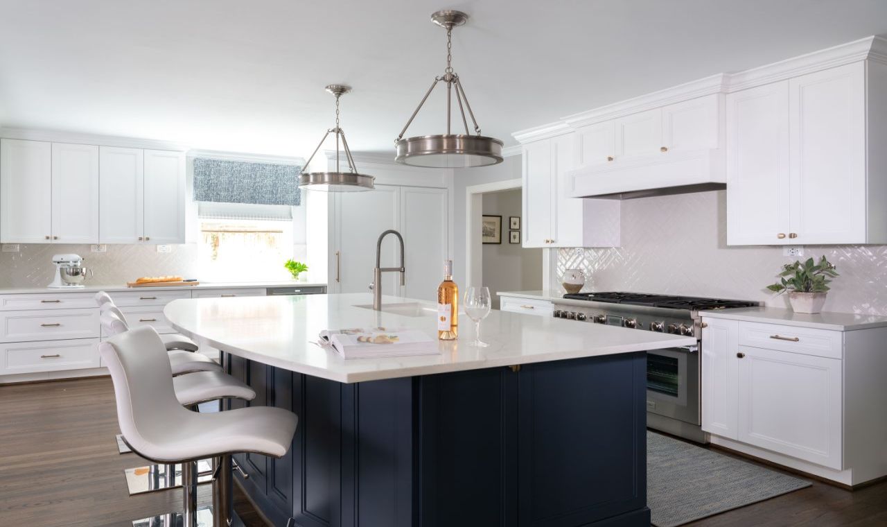 Spacious and stylish, this bright kitchen features white appliances and cabinetry, and a charming blue half curtain over the window matches the blue painted island.