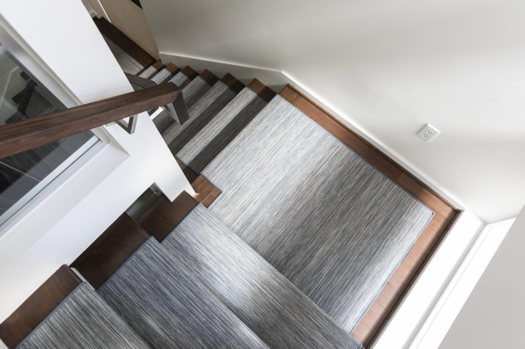 Dark wood stairs with a chic carpet runner take flooring options to the highest standards.