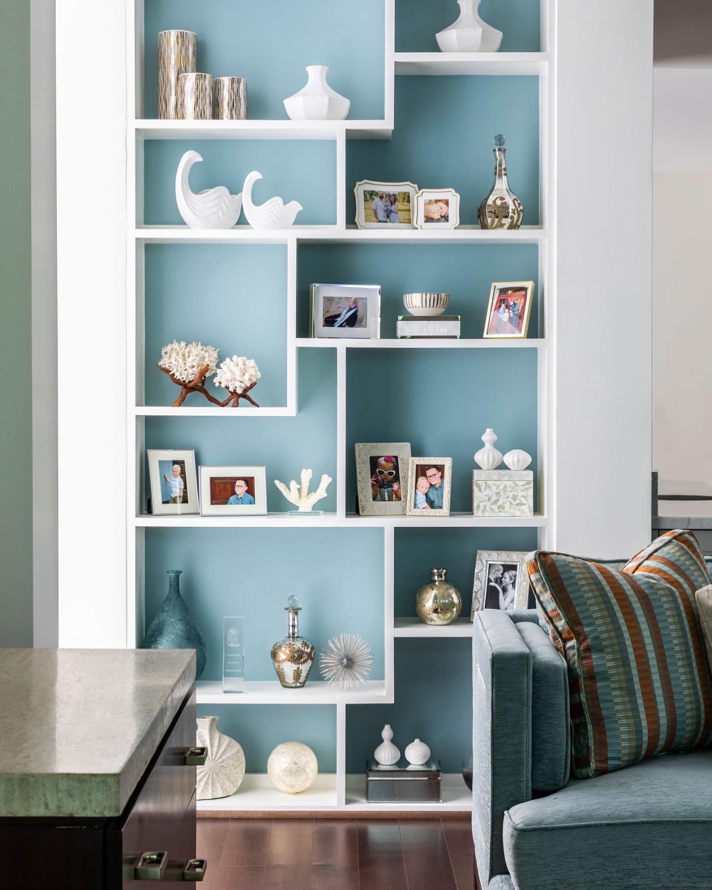 Use of ocean blue paint in the back of bookshelves framed in white