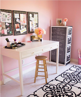 A desk in a pink room.