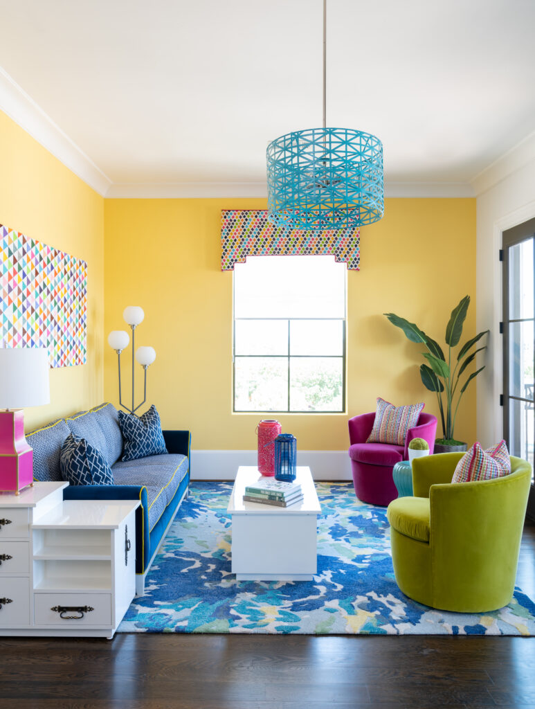 A brightly colored game room with a modern piece painted on wood by Sean Ward called Trichromatic